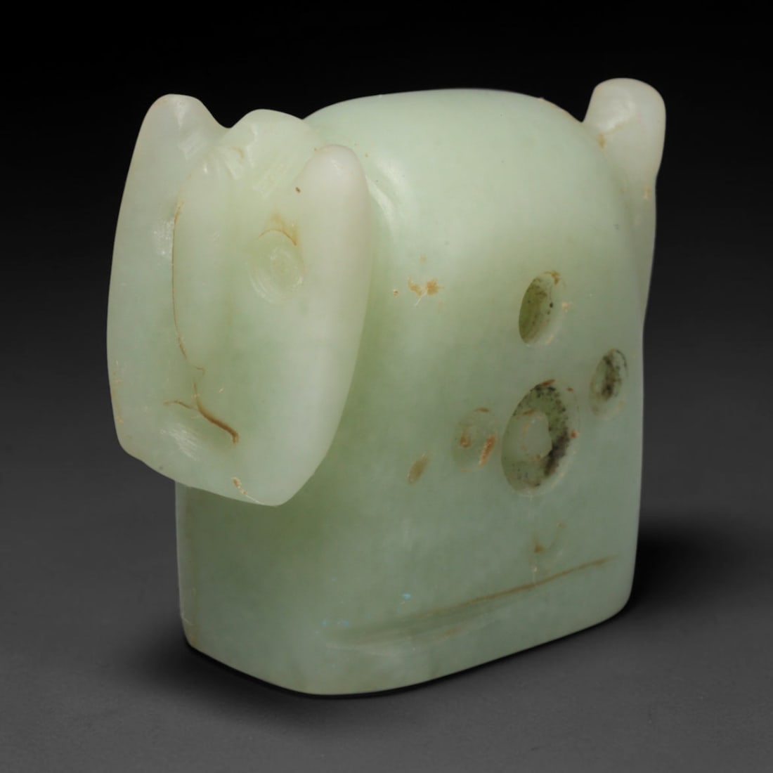 Ancient Sasanian Persian Pale Green Stone Zoomorphic Amulet (c.224-651 CE), 48ED: This pale green stone zoomorphic amulet originates from Ancient Sasanian Persian culture. The stylised animal carving features defined facial features and circular perforated detailing upon its body. 