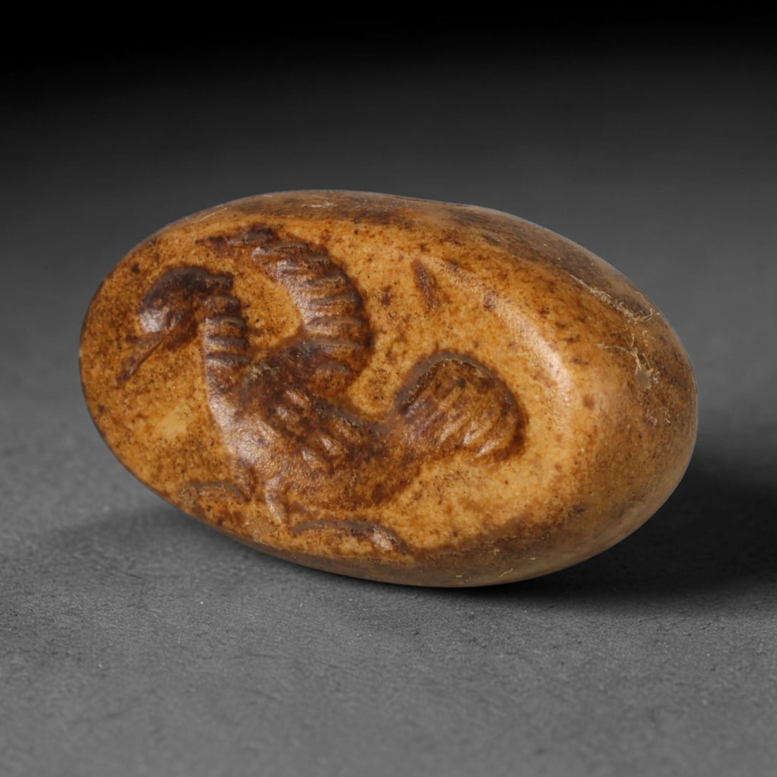 Ancient Sasanian Persian Hemispherical Stone Stamp Seal (c.224-651 CE), 20ED: This warm earth-toned hemispherical stamp seal originates from Ancient Sasanian Persian culture. The oval sealing face features a finely carved relief motif. Crafted with smooth rounded contours, arti