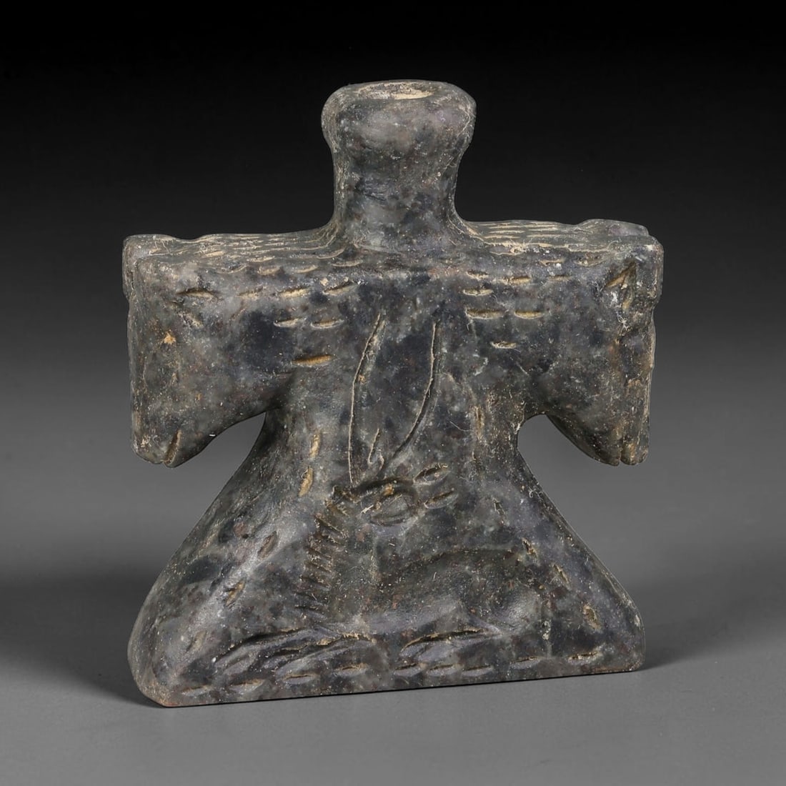 Ancient Syro-Hittite Dark Stone Double-Headed Equine Kohl Vessel (1200-800 BCE), 34EF: This compact cosmetic kohl container is carved from dark mottled stone, originating from Iron Age Syro-Hittite cultures of Northern Syria and Eastern Anatolia. The shoulders are formed by dual horse h