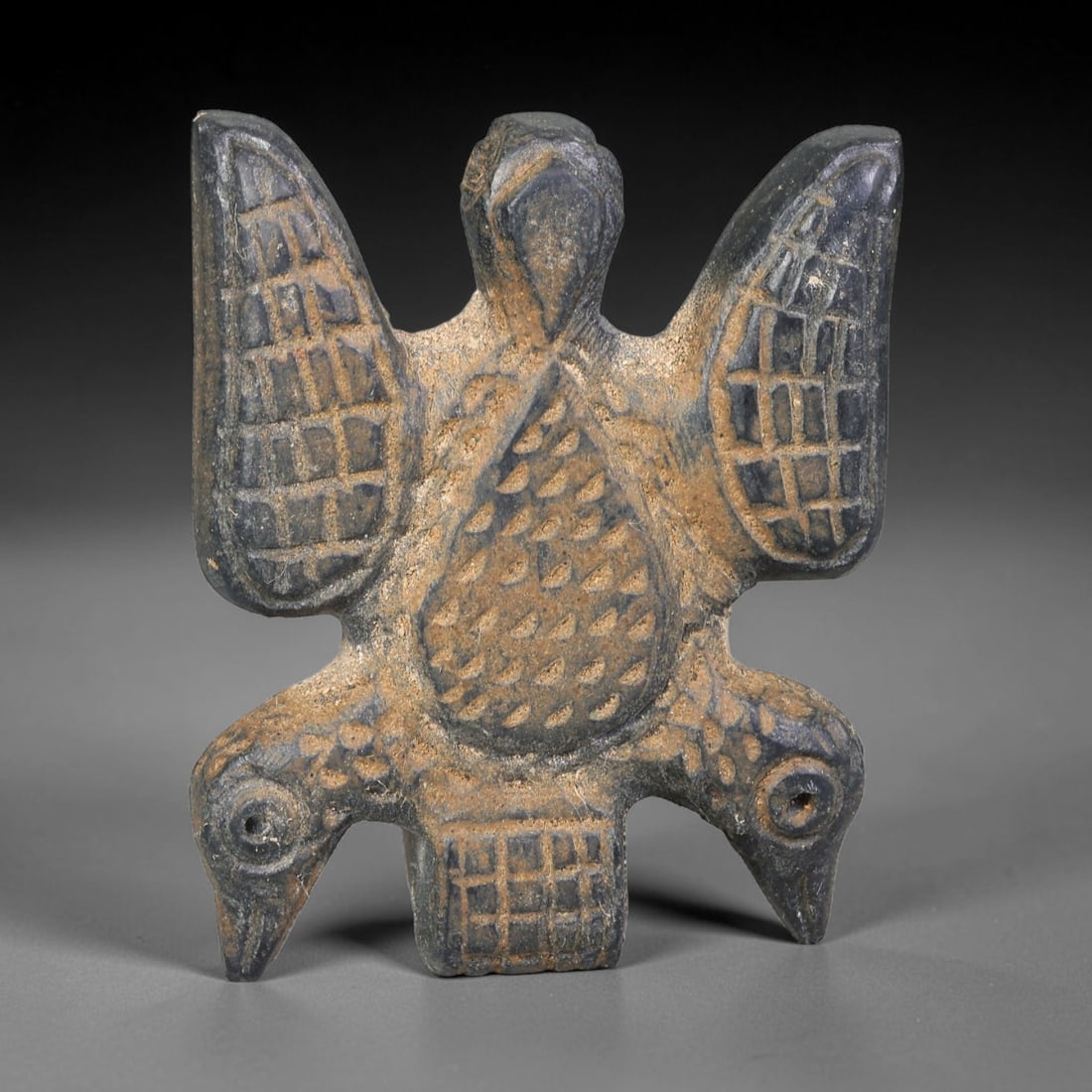 Ancient Syro-Hittite Dark Stone Three-Headed Avian Amulet Plaque (1200-800 BCE), 32EF: This flat zoomorphic amulet plaque is carved from dark stone, originating from Iron Age Syro-Hittite cultures of Northern Syria and Eastern Anatolia. The piece depicts a rare three-headed avian figure