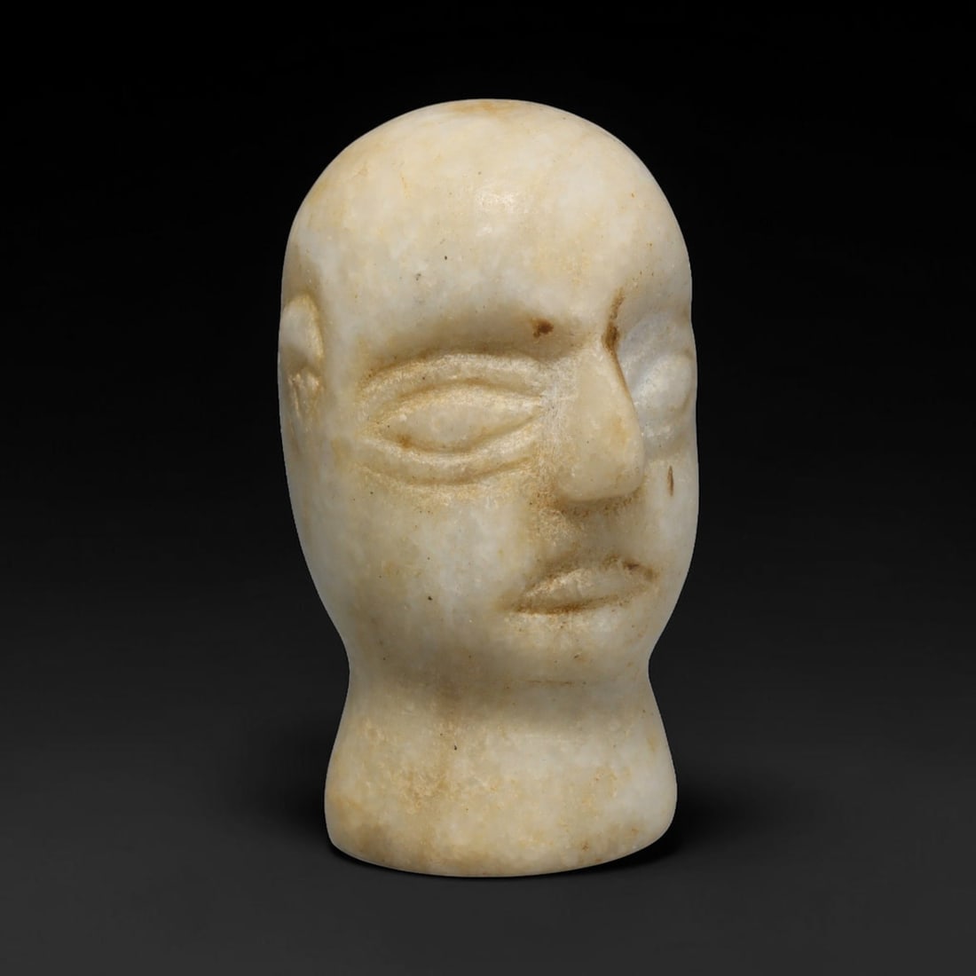 Ancient Bactrian Marble Idol Head (250 BCE-200 CE), 36ED: This carved pale marble idol head originates from Greco-Bactrian Culture, a significant Silk Road civilization blending Hellenistic and Central Asian artistic traditions. The simplified facial feature