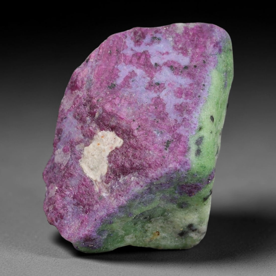 121ct Natural Tanzanian Ruby Zoisite Raw Rough Specimen Mineral Stone, 96FB: This unpolished mineral rough is natural ruby zoisite sourced from Tanzania, exhibiting distinct banded mineral segregation of vibrant green zoisite, magenta ruby crystals, and dark hornblende inclusi