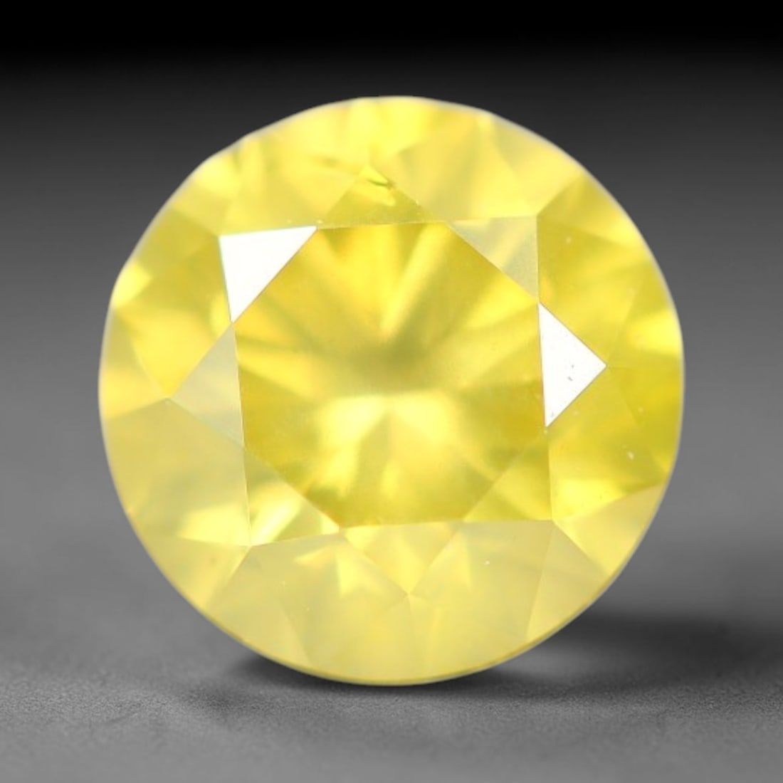 0.41ct Round Natural Fancy Vivid Yellow Diamond Loose Gemstone, 98BE: This polished natural round fancy diamond exhibits vibrant saturated yellow colour, with fine microscopic native mineral specks visible inside the crystal, measured at calibrated dimensions of 4.6x3mm