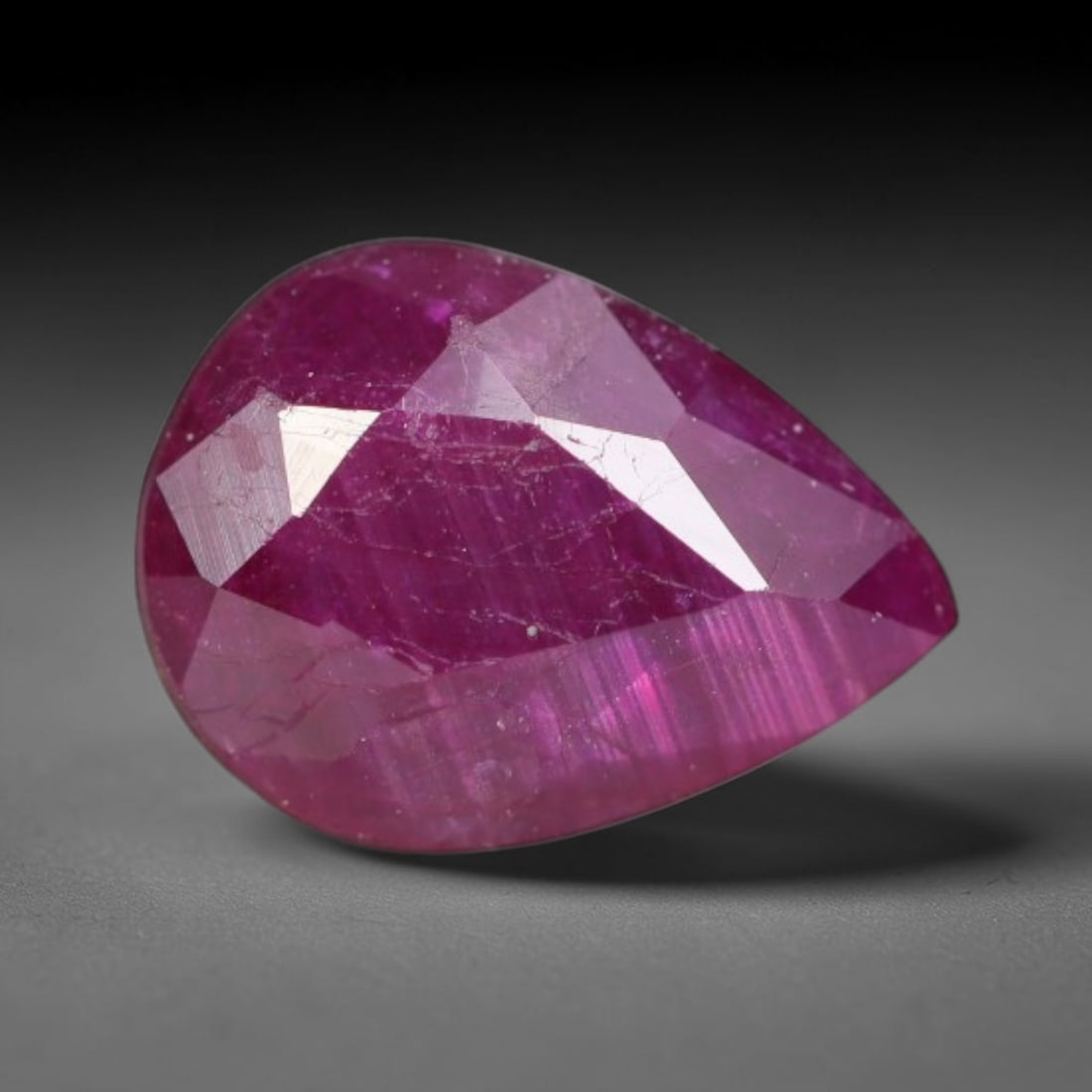 1.22ct Natural Tanzanian Longido Deep Crimson Red Faceted Ruby Loose Gemstone, 86BC: This expertly faceted Longido ruby features a rich deep crimson red body tone with distinct natural linear mineral striations, scattered pale mineral deposits and minor dark mineral flecks visible wit