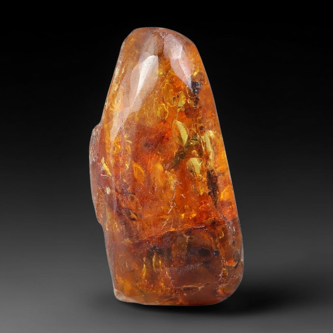 13.50ct Natural Baltic Polished Loose Freeform Amber Gemstone, 21EB: This smoothly polished freeform amber piece carries warm translucent organic clarity with fine natural fossil flecks and tiny mineral inclusions suspended throughout its 28x13mm flowing unstructured s