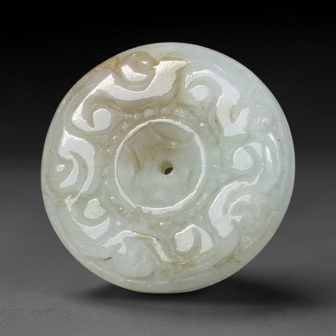 Natural Burmese Type A Jadeite Jade Carved Disc Pendant, 37BP: Artisan hand-carved untreated Burmese Type A jadeite jade circular disc pendant with a 26 mm diameter. The surface is adorned with detailed traditional relief carving finished with a smooth polished s