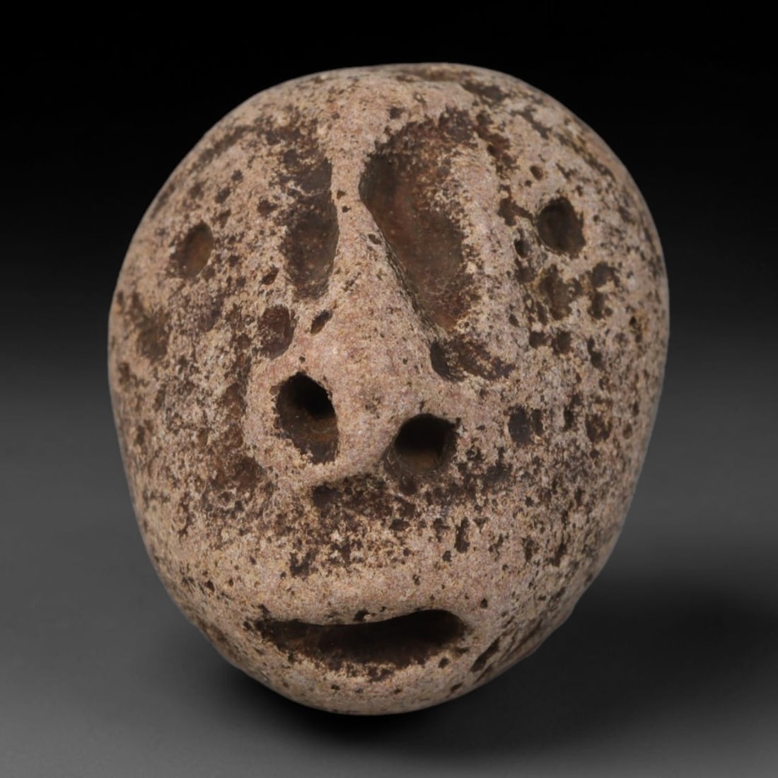 Ancient Medieval Mediterranean Hand Carved Stone Maskette Amulet, 58AP: Miniature wearable sacred talisman hand hewn from natural soft stone, originating from Medieval Mediterranean cultural craft traditions. Small carved stone amulets were widespread personal artifacts a