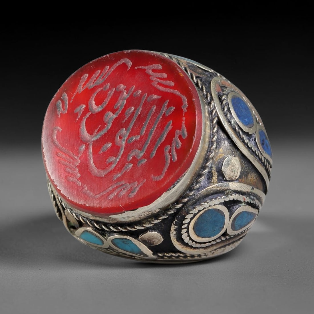 Vintage Islamic Handcrafted Silver Plated Calligraphic Talisman Statement Ring, 14BX: This vintage hand-wrought Islamic statement ring features a central engraved panel bearing traditional calligraphic detailing, set within an ornate silver-plated metal band. The mounting is enriched w