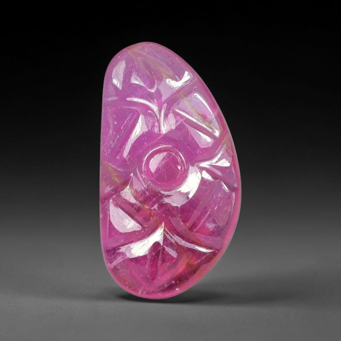 6.30 Carats Natural Mozambique Rich Fuchsia Ruby Loose Gemstone, 39FE: This natural Mozambique ruby cabochon measures 16x8.8x3.5mm and features delicate hand engraved floral detailing carved across its polished surface, with a rich saturated fuchsia hue spread evenly thr
