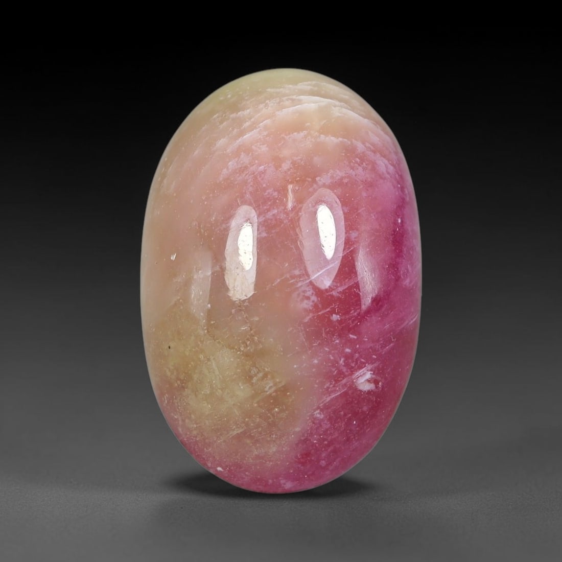 17.51 Carats Natural Mozambique Bicolor Ruby Loose Gemstone, 47FG: This natural Mozambique bicolor ruby cabochon holds dimension measurements of 17.7x11.6x8mm, displaying soft swirled intermix of rich pink and pale creamy mineral tones that blend seamlessly across th