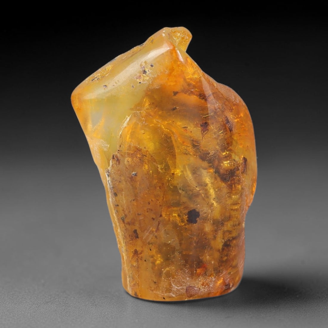 22ct Natural Baltic Polished Loose Freeform Amber Gemstone, 54EB: This smoothly polished freeform amber piece carries warm translucent organic clarity with fine natural fossil flecks and tiny mineral inclusions suspended throughout its 33x21mm flowing unstructured s