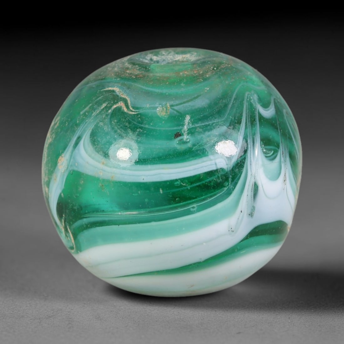 Swirled Green Blown Glass Bead - Handmade Vintage Spherical Ornament, 18AE: Hand-blown glass composes this spherical bead, defined by fluid layered swirls of deep emerald green, soft mint green and opaque white glass forming continuous marbled striations across its polished e