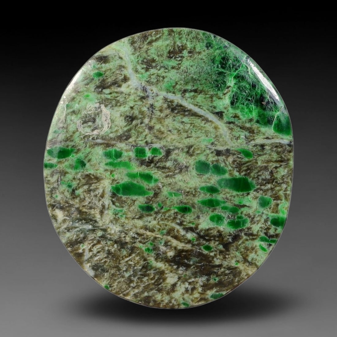 14ct Natural Burmese Type A Emerald Spot Scenic Matrix Jadeite Jade Cabochon, 35FA: This single untreated natural Burmese Type A oval jadeite jade cabochon weighs 14ct with dimensions of 25.3x22.6x3mm. The earthy brown textured matrix is scattered with vivid emerald green rounded pat