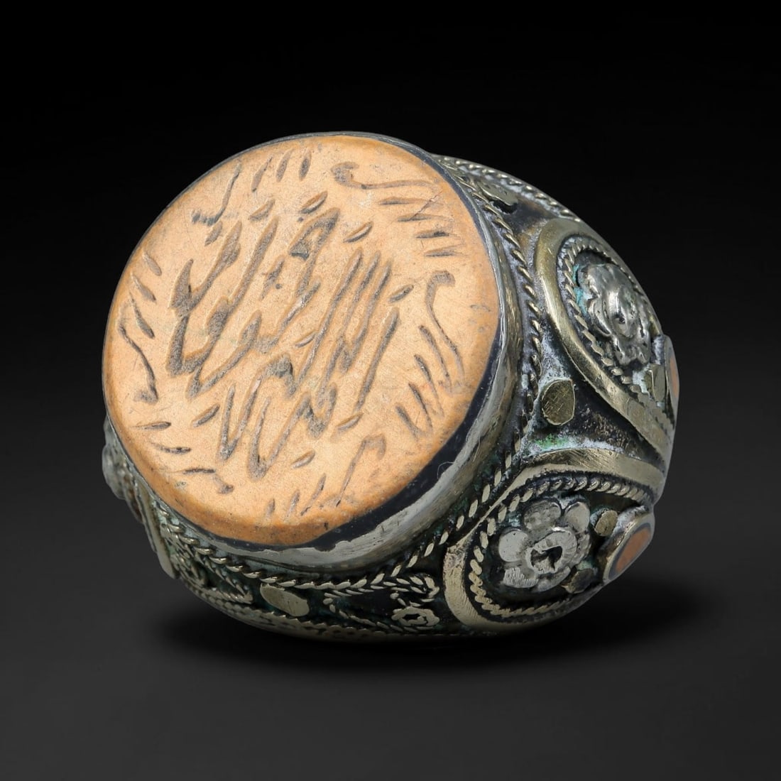 Vintage Islamic Handcrafted Silver Plated Calligraphic Talisman Statement Ring, 18BX: This vintage hand-wrought Islamic statement ring features a central engraved panel bearing traditional calligraphic detailing, set within an ornate silver-plated metal band. The mounting is enriched w