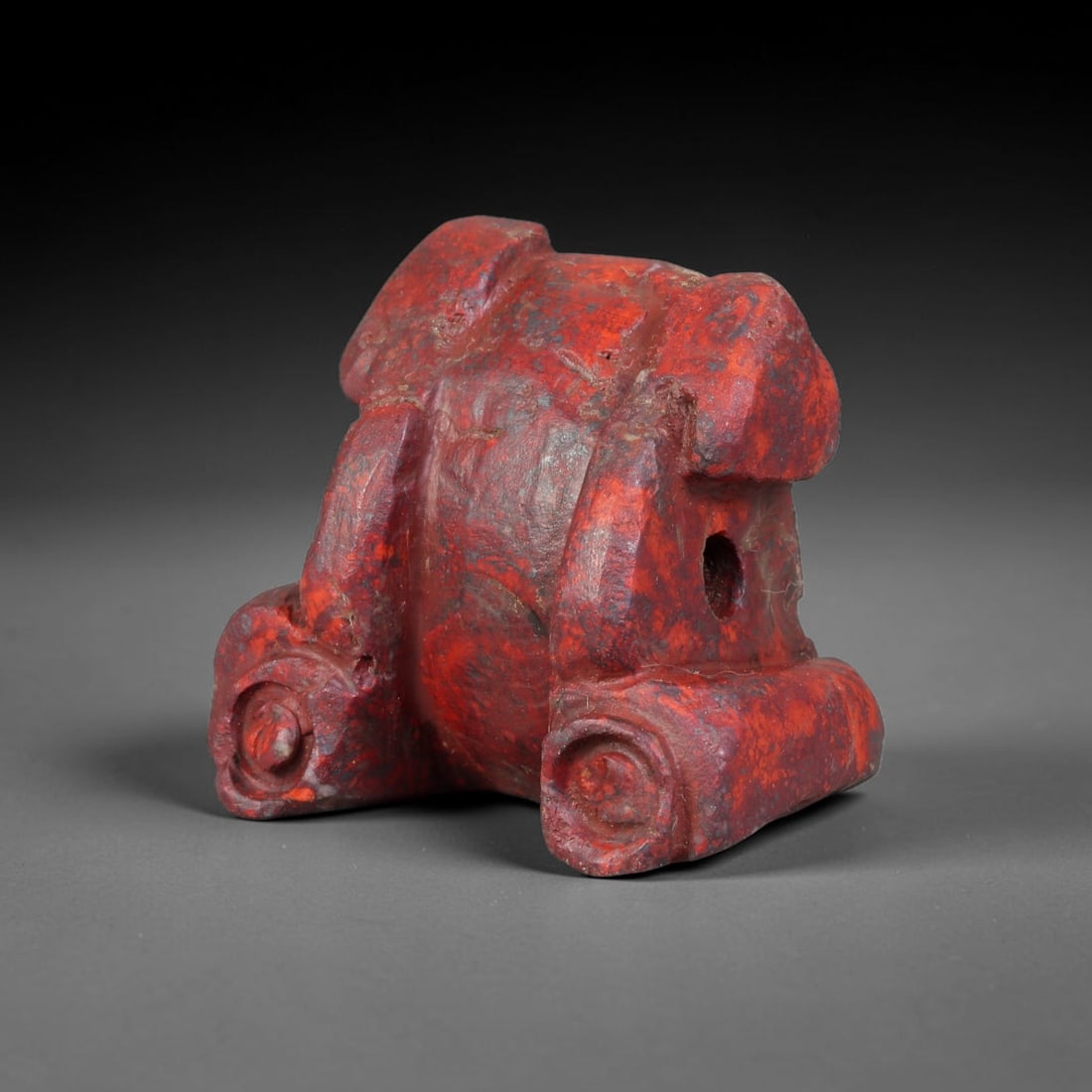 Ancient Western Asiatic Natural Red Jasper Rhinoceros Head Zoomorphic Amulet (1000-600 BCE), 69AB,,: Hand-carved deep red jasper talisman shaped as a stylized rhinoceros head with prominent rounded horn protrusions and circular incised eye detailing. Natural mottled crimson and dark mineral veining r