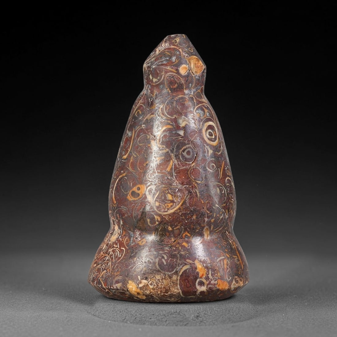 Ancient Medieval Mamluk Fossil Stone Conical Talisman (13th-16th Centuries CE), 26EF: This finely polished conical talisman is crafted from decorative fossil-bearing stone originating from the medieval Mamluk realm. The piece features a tiered base rising to a sharp tapered point, show