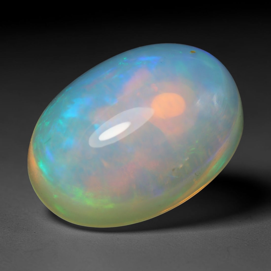 5.80ct Natural Ethiopian Welo Opal Cabochon Loose Gemstone, 19BY: This smoothly polished cabochon is genuine natural Ethiopian Welo opal. The translucent base hosts vivid multi-coloured play-of-colour, displaying dynamic flashes of multi color that shift as the view
