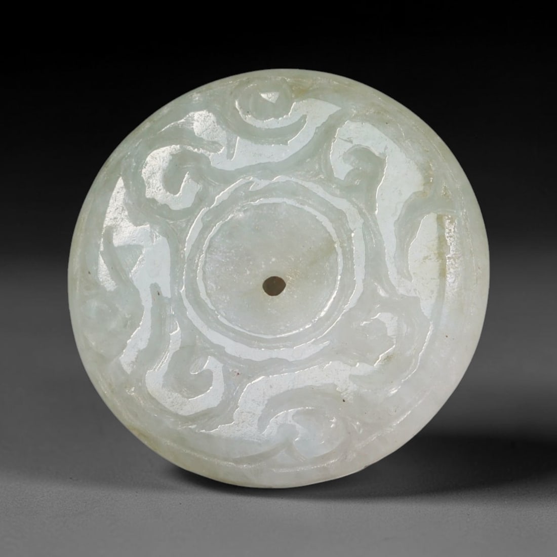 Natural Burmese Type A Jadeite Jade Carved Disc Pendant, 56BP: Artisan hand-carved untreated Burmese Type A jadeite jade circular disc pendant with a 26 mm diameter. The surface is adorned with detailed traditional relief carving finished with a smooth polished s