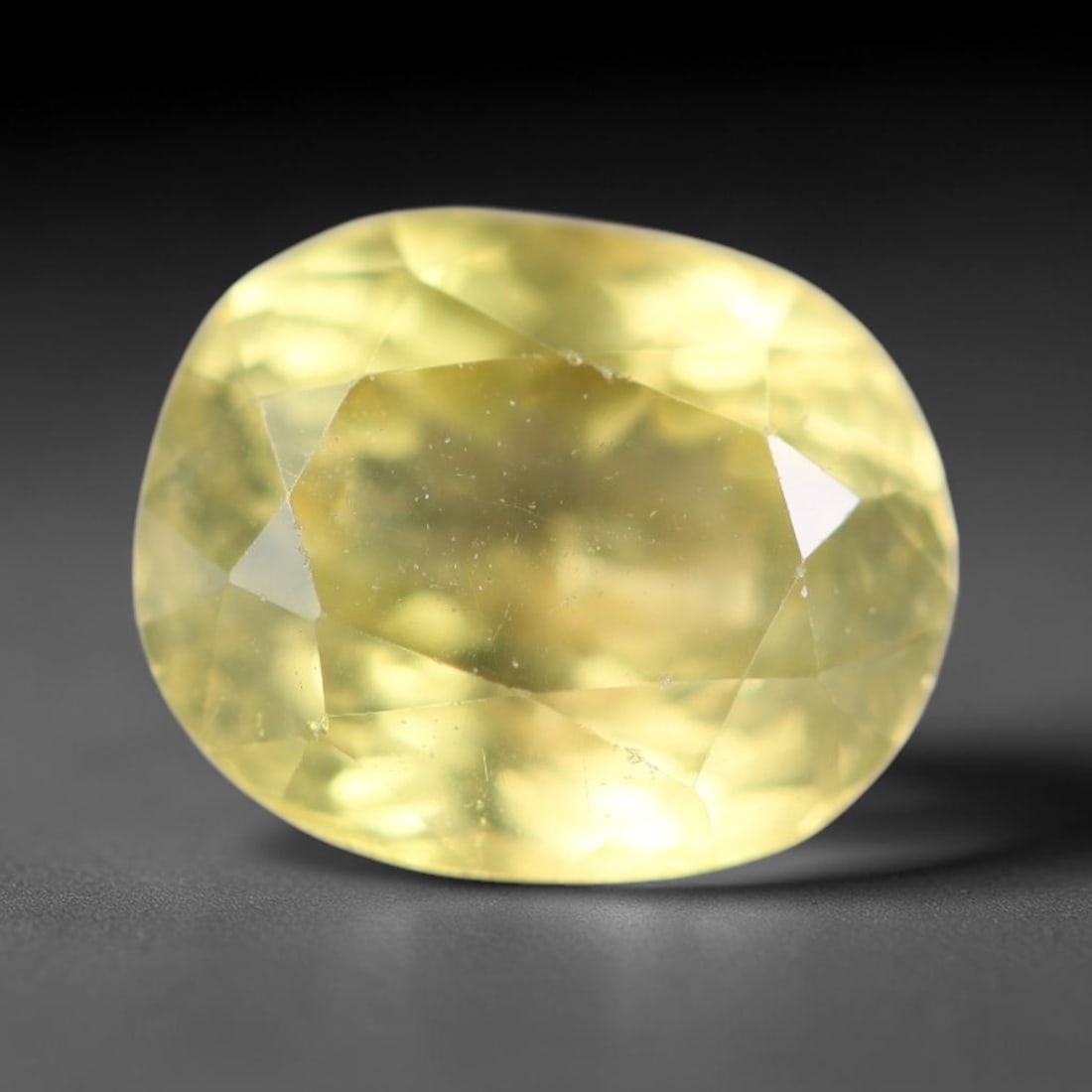 2.00ct Natural Mexican Lemon Yellow Faceted Apatite Loose Gemstone, 30BC: This expertly faceted yellow apatite holds translucent pale lemon yellow crystal structure with faint tiny internal mineral specks and subtle fine linear markings visible beneath its precisely polishe