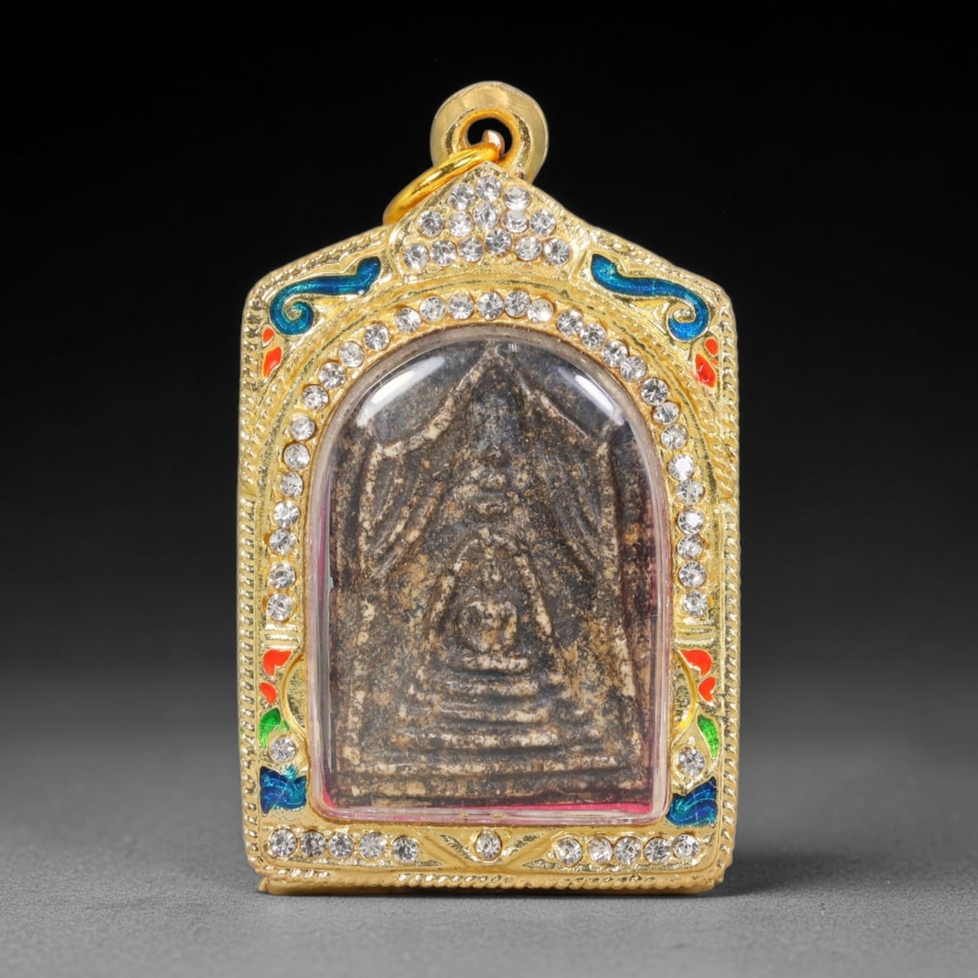 Thai Buddhist Folk Tradition Enclosed Amulet Pendant with Decorative Metal Casing, 9AH: This Thai sacred amulet is housed within an ornate hinged metal protective casing fitted with a top loop for wear as a pendant. The casing features intricate embossed surface detailing and a continuou