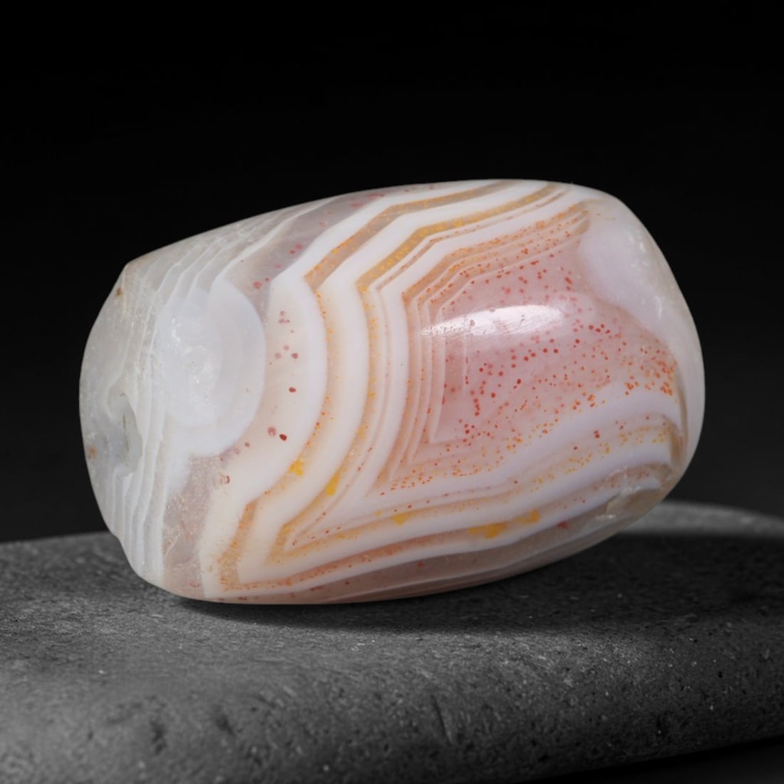 Ancient Chaldean Neo-Babylonian Geometric Speckled Banded Agate Barrel Bead (626-539 BCE), 74AD: This antique banded agate barrel bead originates from the Chaldean Neo-Babylonian Dynasty, a late Mesopotamian power renowned for intricate lapidary craft creating sacred talismanic agate beads for te