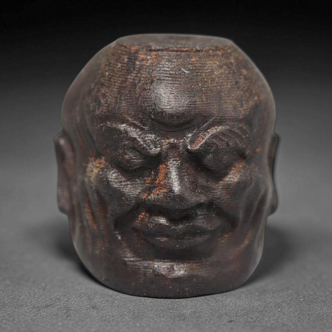 A Chinese Agar Wood Carved Head Art Bead, 29BX: Chinese agar wood head-form art bead measuring 22 x 20 mm. Detailed sculpted facial features cover the exterior surface, with a continuous central bore designed for stringing within beaded strands. Th