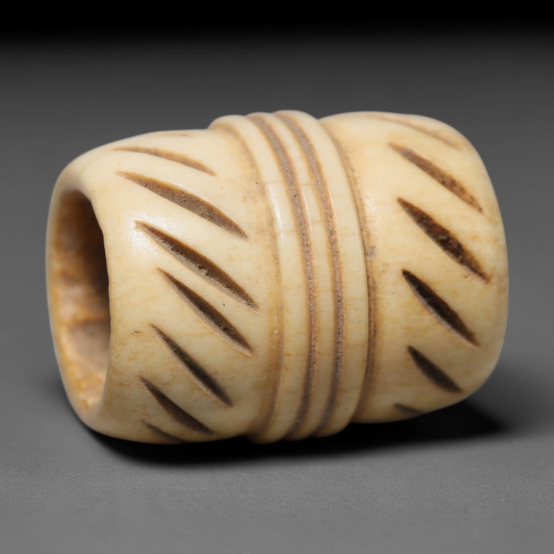 Antique Sino-Siberian Steppe Nomadic Craft Stag Antler Carved Cylinder Bead (Post 1850s), 11FV: Single bead carved from natural stag antler, originating from Sino-Siberian Steppe Nomadic craft traditions, post 1850s. Measuring 2cm, the piece features detailed surface carving and carries warm nat