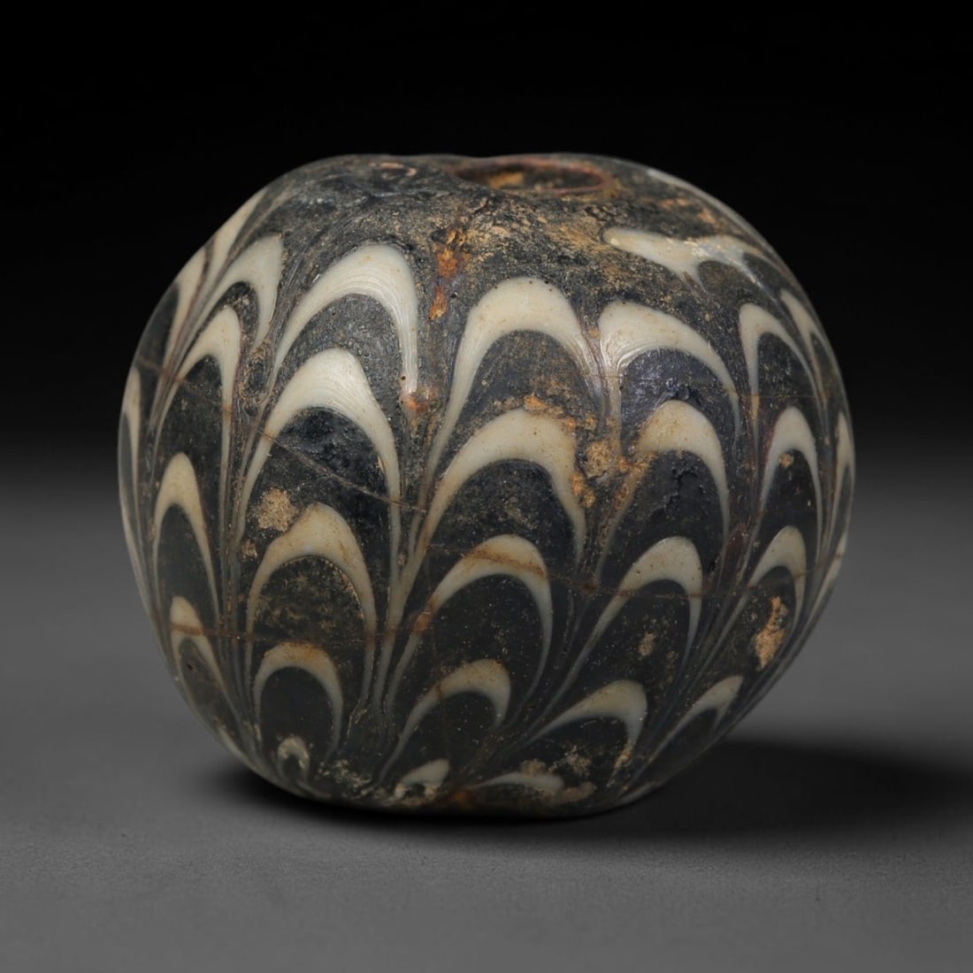Ancient Islamic Hand Crafted Glass Bead Talisman, 30AC: Miniature antique wearable bead formed from hand-worked glass material, originating from ancient Islamic period glassmaking traditions across the Near East and North African cultural spheres. Glass wa