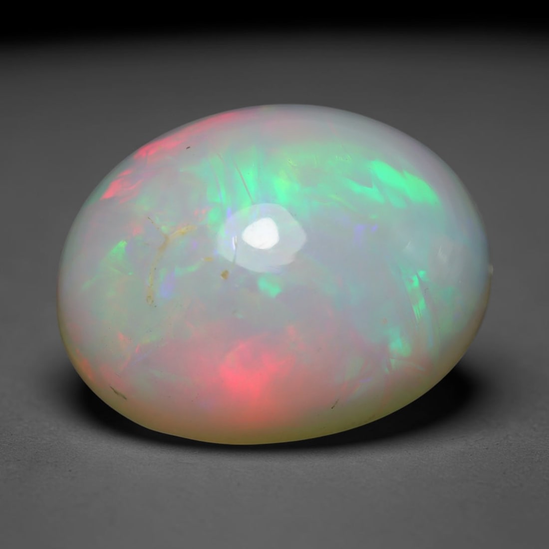 5.77ct Natural Ethiopian Welo Opal Cabochon Loose Gemstone, 17BY: This smoothly polished cabochon is genuine natural Ethiopian Welo opal. The translucent base hosts vivid multi-coloured play-of-colour, displaying dynamic flashes of multi color that shift as the view