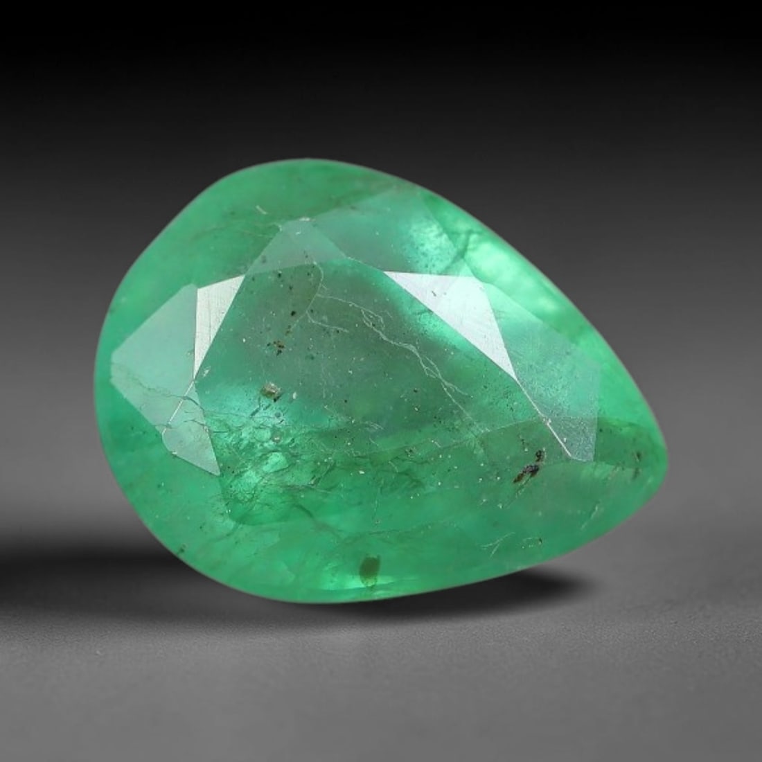 1.25 Carats Natural Zambian Green Emerald Loose Gemstone, 15FP: This green Zambian emerald holds smooth even saturation with subtle faint natural internal markings lending authentic organic character, measured at 7.7x5.8x4.4mm, its calm cool green tone delivers un