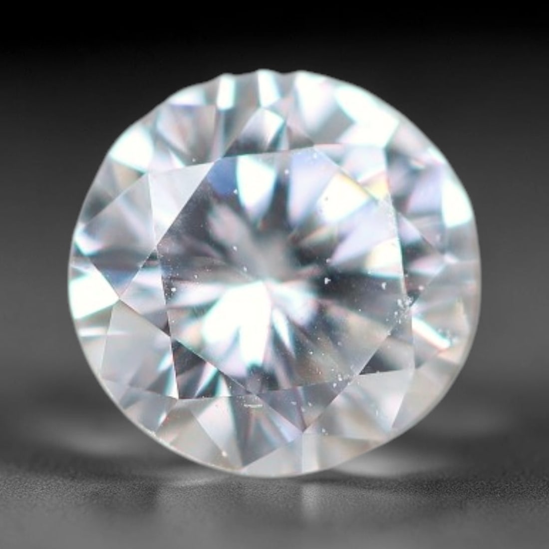 0.11ct Lab-Grown White Round Brilliant HPHT Diamond Loose Gemstone, 85BE: This precision-cut HPHT lab-grown diamond exhibits brilliant colourless transparency, dotted with subtle microscopic growth features within its crystal structure, measured at calibrated dimensions of 
