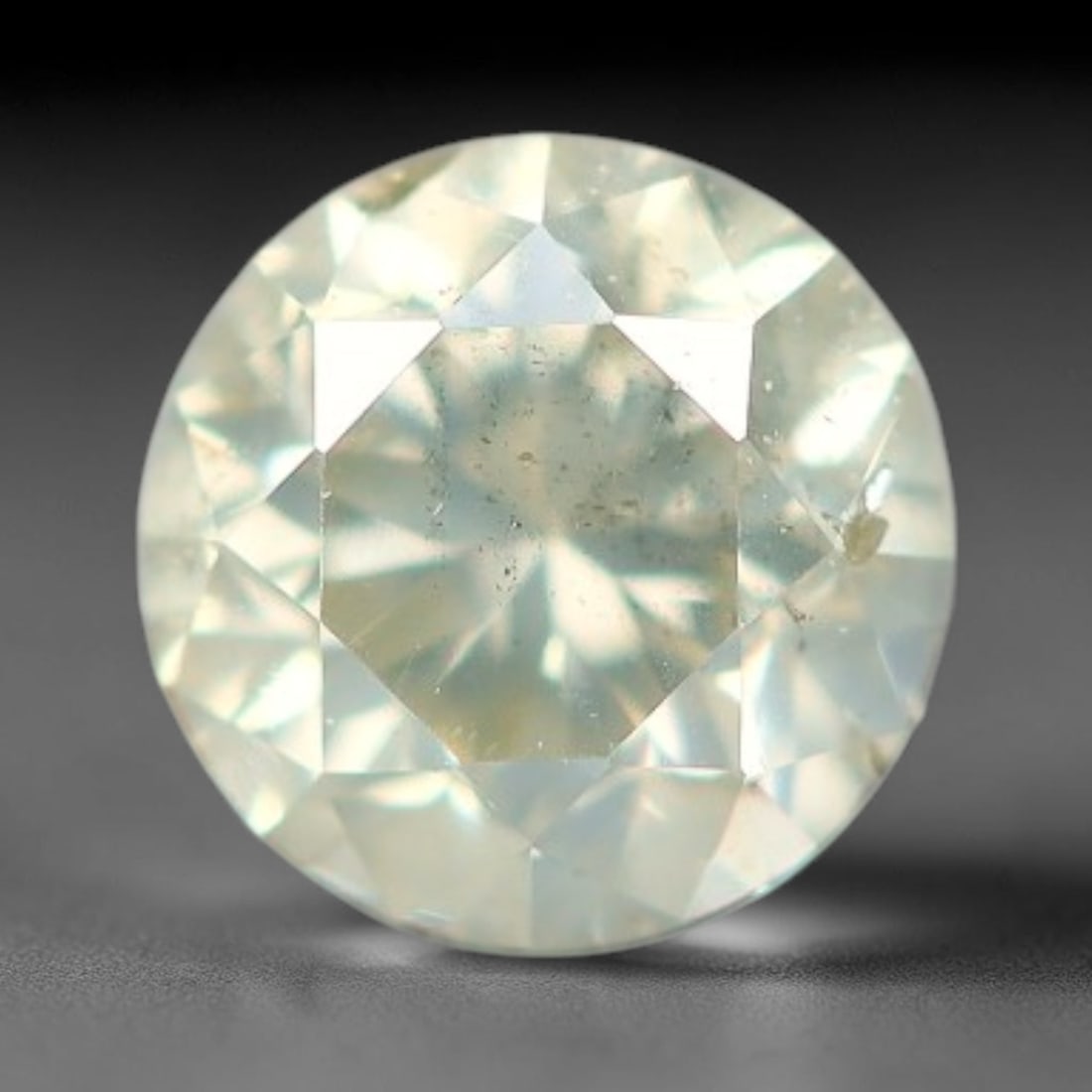 0.20ct Round Natural Fancy Greenish Yellow Diamond Loose Gemstone, 53BH: This polished natural round fancy diamond displays a delicate greenish-yellow base tone, with scattered fine native mineral specks distributed within its crystalline interior, measured at calibrated d