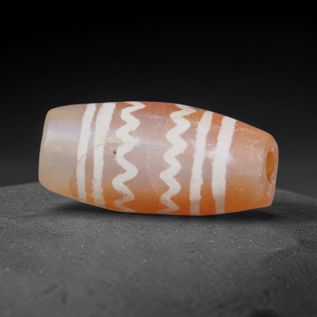 Antique Sino-Himalayan Region Etched Carnelian Bead, 16EH: Antique etched carnelian bead originating from the Sino-Himalayan region. Exhibits characteristic surface patina and traditional etched white decoration. Dimensions: 18x8mm, fully pierced for suspensi