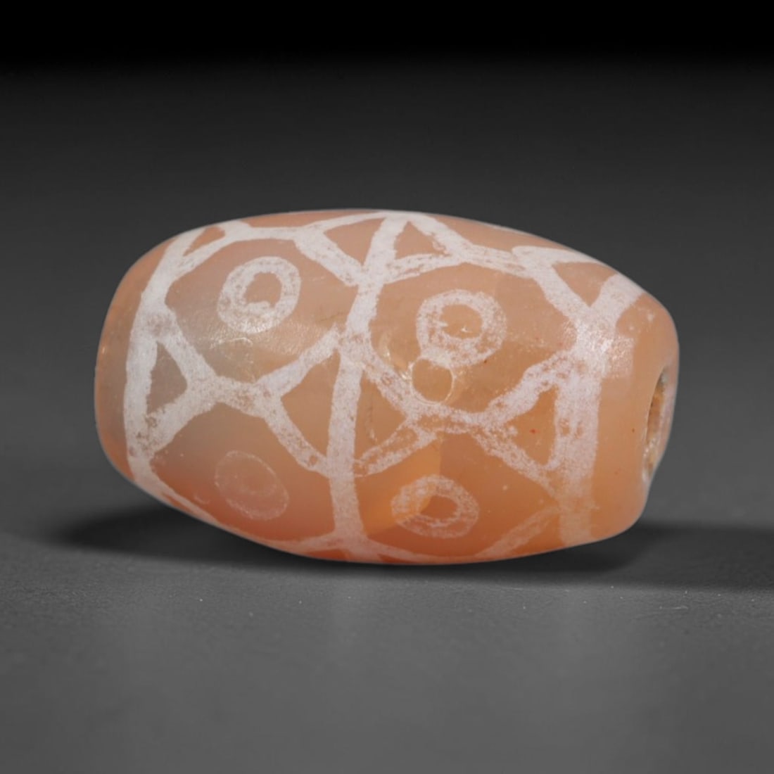 Antique Sino-Himalayan Region Etched Carnelian Bead, 7EH: Antique etched carnelian bead originating from the Sino-Himalayan region. Exhibits characteristic surface patina and traditional etched white decoration. Dimensions: 14x8mm, fully pierced for suspensi