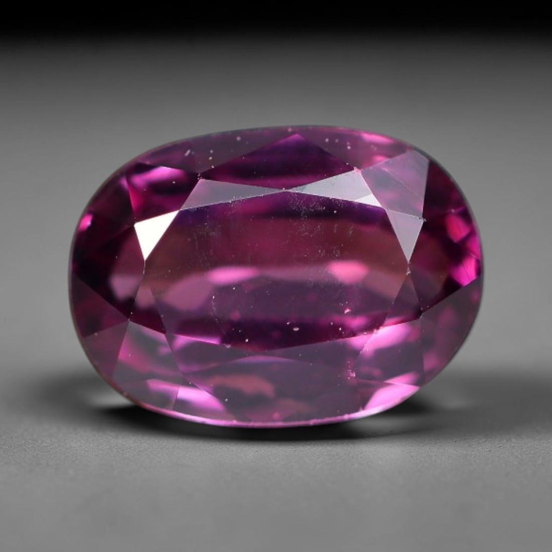 1.19ct Natural Tanzanian Rhodolite Grape Garnet Faceted Loose Gemstone, 3BE: This expertly faceted grape garnet, a scarce saturated purple-magenta rhodolite variant, features transparent crystal structure dotted with faint microscopic mineral specks within its precisely cut re