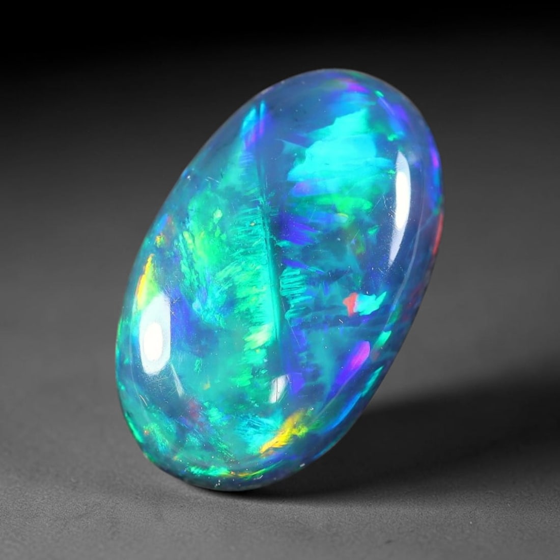 2.74ct Natural Ethiopian Welo Black Smoked Opal Cabochon Loose Gemstone, 23FX: This fully polished Ethiopian Welo opal features a dark smoked base with vivid, sweeping play-of-color shifting across its glossy dome surface, measured at 12x7x5mm. The black smoke treatment deepens 