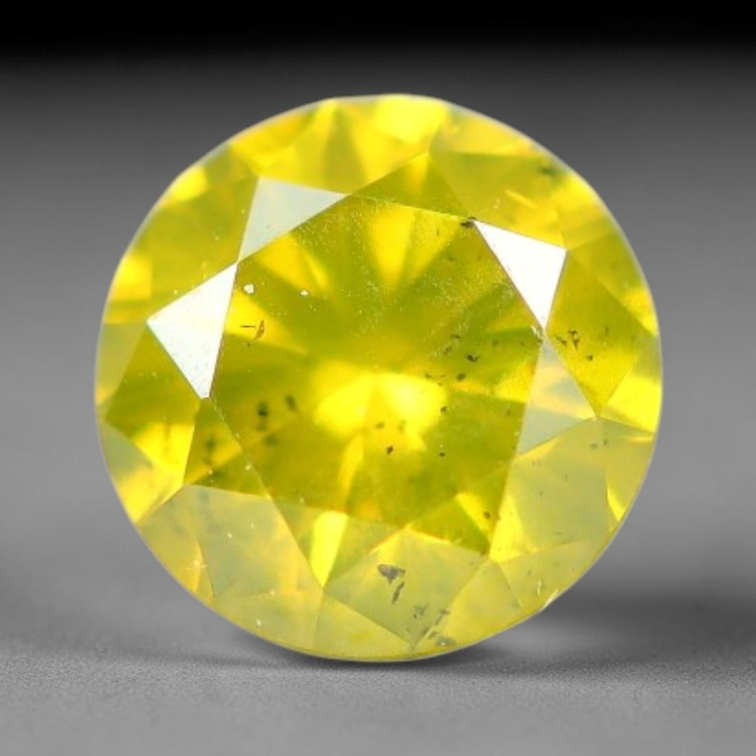 0.17ct Round Natural Fancy Vivid Yellow Diamond Loose Gemstone, 5BH: This polished natural round fancy diamond exhibits vibrant saturated yellow colour, with fine microscopic native mineral specks visible inside the crystal, measured at calibrated dimensions of 3.5x2.1