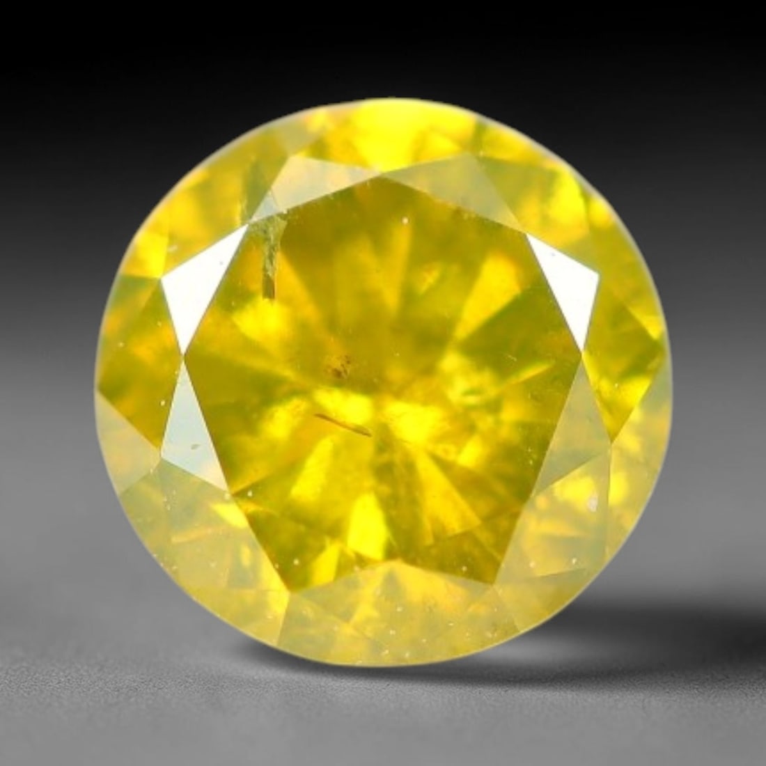 0.19ct Round Natural Fancy Vivid Yellow Diamond Loose Gemstone, 6BH: This polished natural round fancy diamond exhibits vibrant saturated yellow colour, with fine microscopic native mineral specks visible inside the crystal, measured at calibrated dimensions of 3.6x2.1