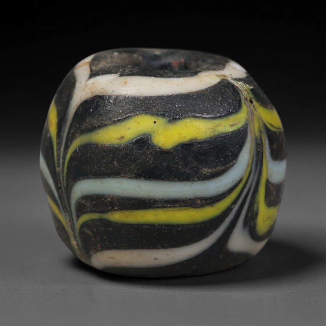 Ancient Islamic Hand Crafted Glass Bead Talisman, 31AC: Miniature antique wearable bead formed from hand-worked glass material, originating from ancient Islamic period glassmaking traditions across the Near East and North African cultural spheres. Glass wa