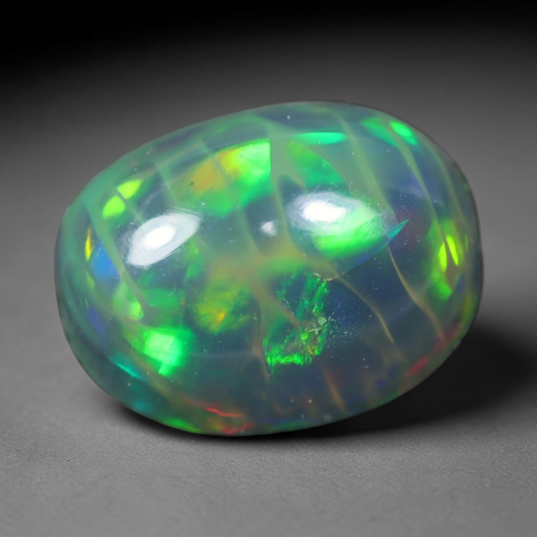 2.01ct Natural Ethiopian Welo Black Smoked Opal Cabochon Loose Gemstone, 39FL: This fully polished Ethiopian Welo opal features a dark smoked base with vivid, sweeping play-of-color shifting across its glossy dome surface, measured at 10x7.9x5.6mm. The black smoke treatment deep