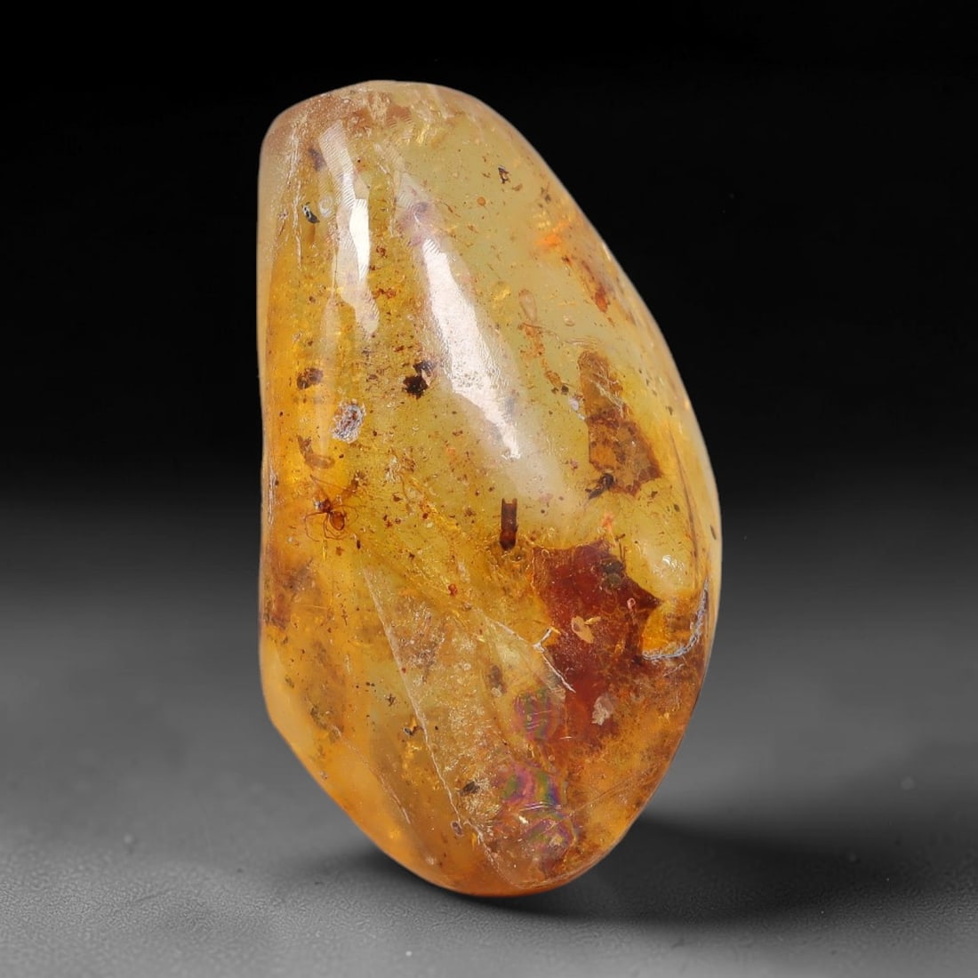 19.85ct Natural Baltic Polished Loose Freeform Amber Gemstone, 52EB: This smoothly polished freeform amber piece carries warm translucent organic clarity with fine natural fossil flecks and tiny mineral inclusions suspended throughout its 32x18mm flowing unstructured s