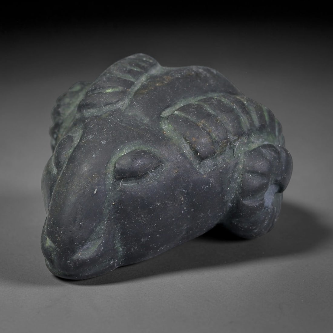 Ancient Sasanian Persian Ram Head Amulet Bead (224-651 CE), 19EC: This antique ram head amulet bead originates from the Sasanian Persian Empire, where ram zoomorphic talismans symbolized power, fertility and divine protection. The carving displays stylized layered c
