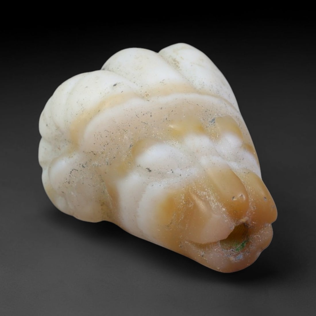 Ancient Sasanian Persian Agate Ram Head Amulet Bead (224-651 CE), 35EC: This antique ram head amulet bead carved from natural agate originates from the Sasanian Persian Empire. Ram motifs stood as powerful symbols of fertility, strength and divine protection within ancien