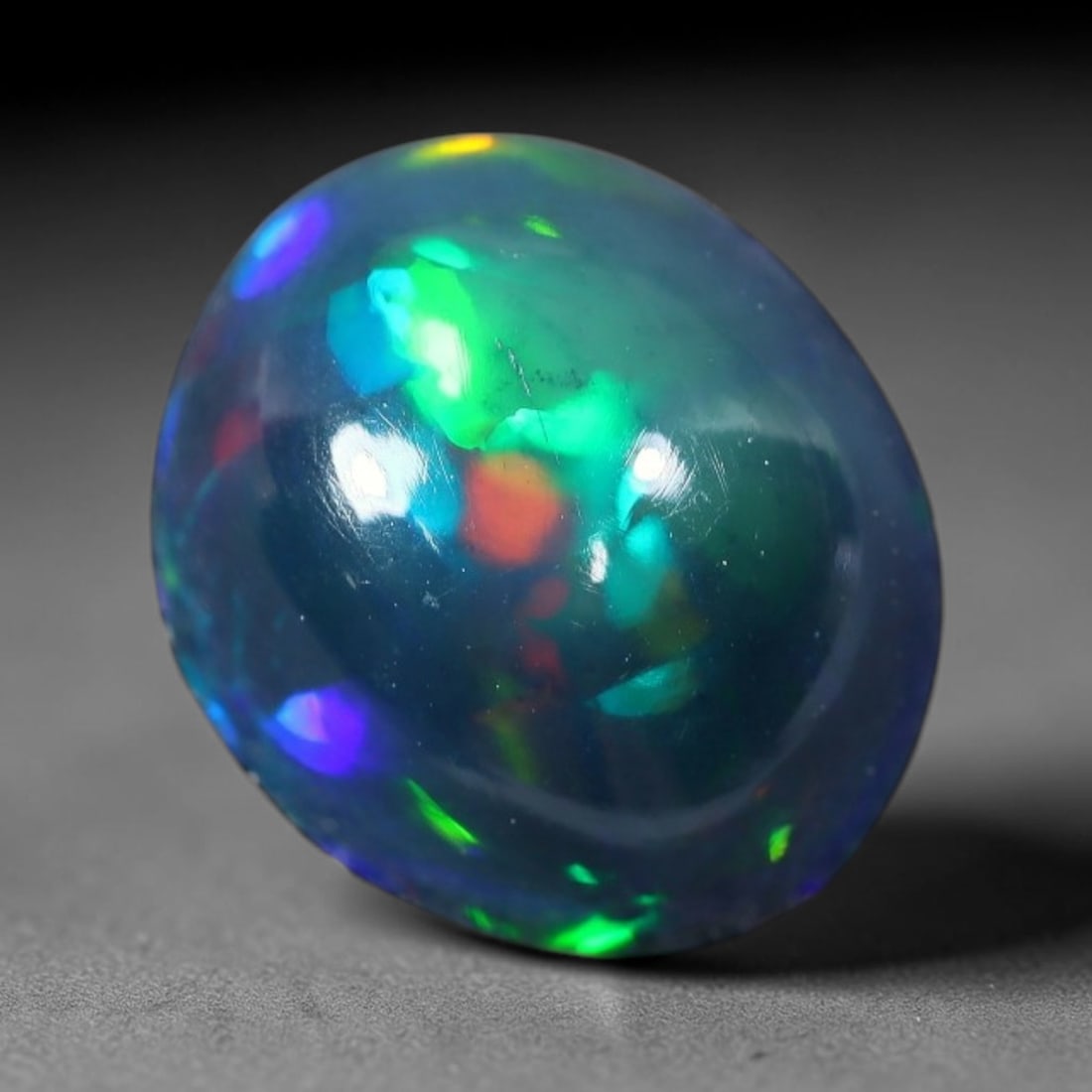 2.81ct Natural Ethiopian Welo Black Smoked Opal Cabochon Loose Gemstone, 48FX: This fully polished Ethiopian Welo opal features a dark smoked base with vivid, sweeping play-of-color shifting across its glossy dome surface, measured at 10x9x6mm. The black smoke treatment deepens 