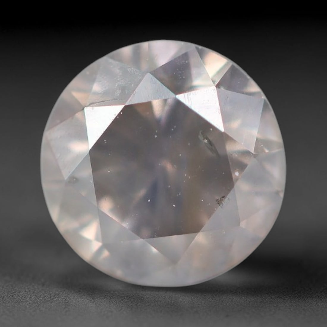 0.53ct Natural Fancy Pale Grey Diamond Round Cut Loose Gemstone, 43BH: This polished natural round cut fancy diamond displays soft pale grey body tone, with scattered fine native mineral specks and subtle internal crystal features throughout the gem, measured at calibrat