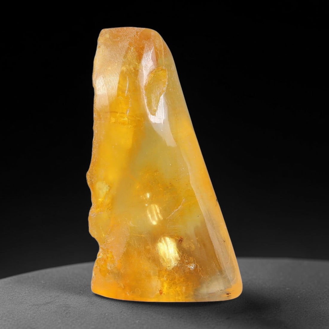 16.41ct Natural Baltic Polished Loose Freeform Amber Gemstone, 28EB: This smoothly polished freeform amber piece carries warm translucent organic clarity with fine natural fossil flecks and tiny mineral inclusions suspended throughout its 33x18mm flowing unstructured s