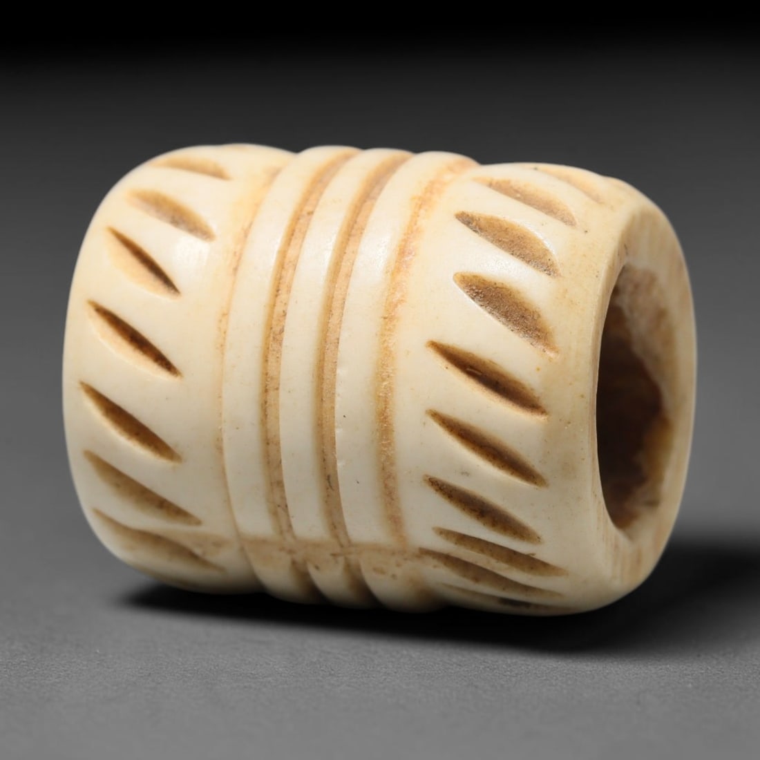 Antique Sino-Siberian Steppe Nomadic Craft Stag Antler Carved Cylinder Bead (Post 1850s), 65FV: Single bead carved from natural stag antler, originating from Sino-Siberian Steppe Nomadic craft traditions, post 1850s. Measuring 2cm, the piece features detailed surface carving and carries warm nat