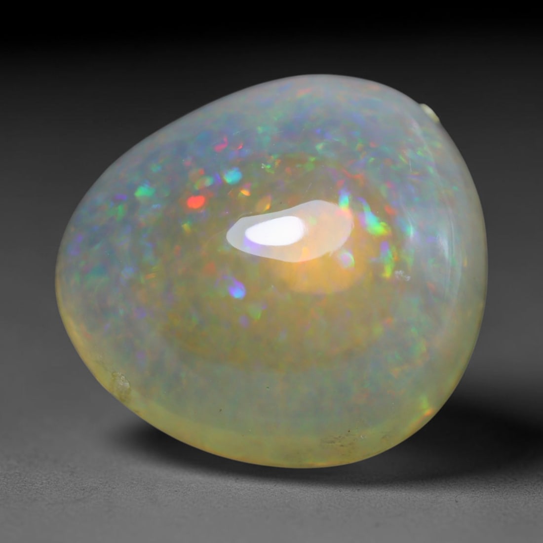 14.76ct Natural Ethiopian Welo Opal Cabochon Loose Gemstone, 16BY: This smoothly polished cabochon is genuine natural Ethiopian Welo opal. The translucent base hosts vivid multi-coloured play-of-colour, displaying dynamic flashes of multi color that shift as the view