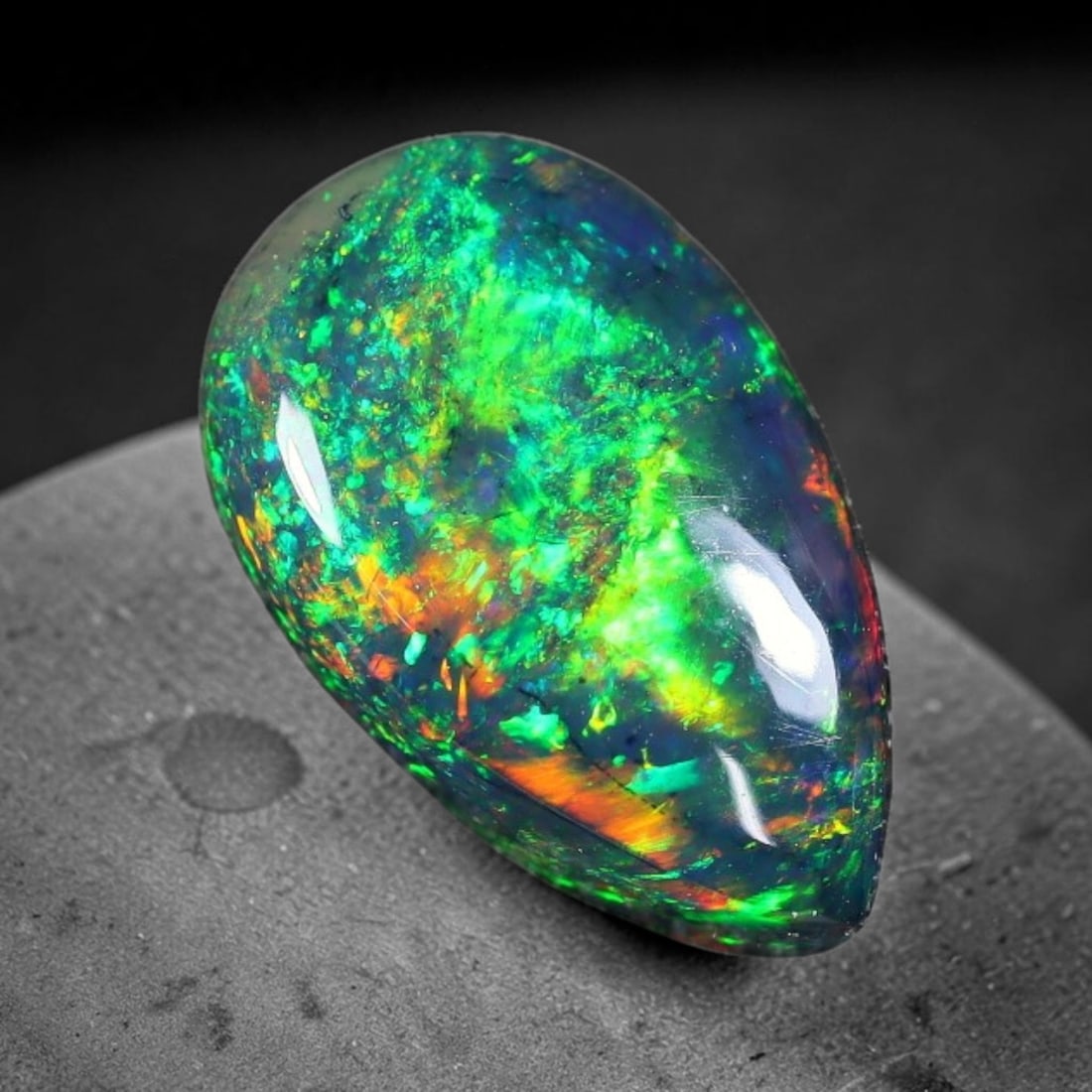 1.80ct Natural Ethiopian Welo Black Smoked Opal Cabochon Loose Gemstone, 75FX: This fully polished Ethiopian Welo opal features a dark smoked base with vivid, sweeping play-of-color shifting across its glossy dome surface, measured at 11x8x4mm. The black smoke treatment deepens 