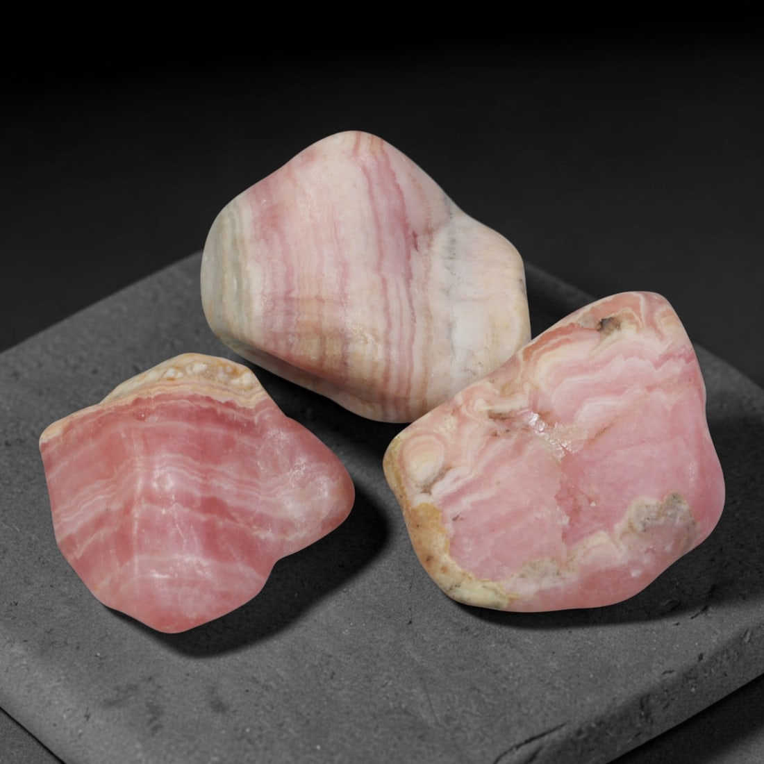 64ct 3pcs Natural Argentine Rhodochrosite Banded Tumbled Rough Set, 14FD: This listing features three individual tumbled rhodochrosite rough pieces sourced from Argentina Capillitas deposits, each showcasing distinct layered banding of soft rose pink, cream white and pale t